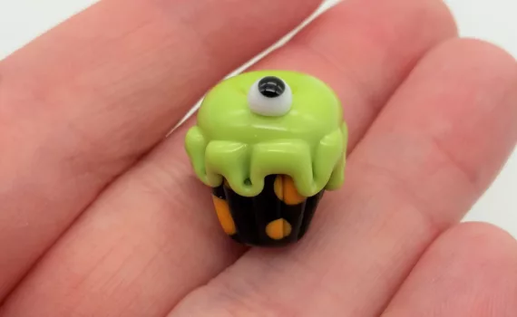 Lampwork glass bead cupcake with slime green frosting and an eyeball.