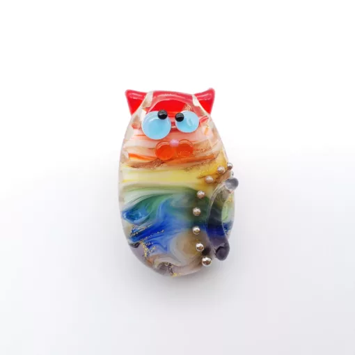 Large lampwork glass bead cat, with golden pealrs and rainbow swirls.