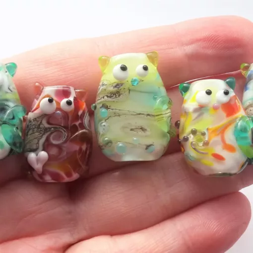 A collection of lampwork glass focal beads, resembling cats.
