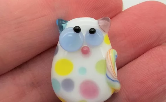 Lampwork glass bead cat with confetti dots and kooky eyes.